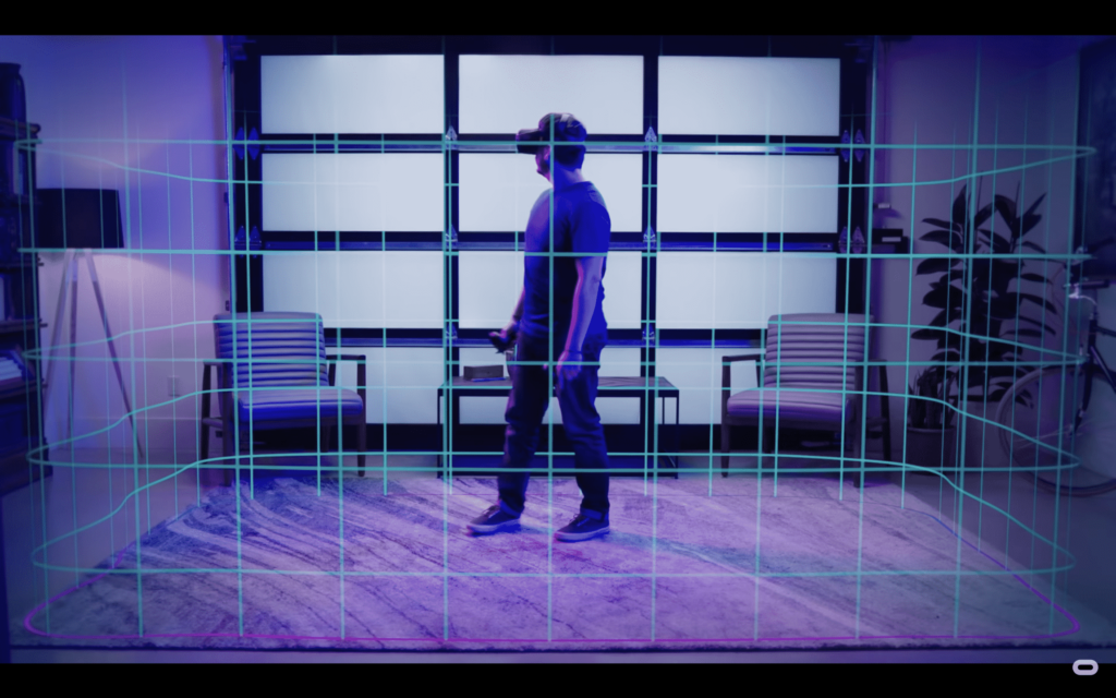 Das Bild zeigt einen Mann in einem Wohnzimmer, wie er mit der Oculus-Brille auf dem Kopf seinen Guardian einrichtet. Der Guardian erscheint im Bild als filigrane Linien. So wird er auch im virtuellen Raum visualisiert.
